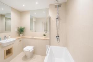 a bathroom with a toilet and a sink and a shower at Elegant Flat with Balcony in Finchley in Hendon +28 photos