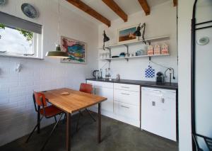 a kitchen with a wooden table and a table and chairs at Hemhuisje in Zaandam
