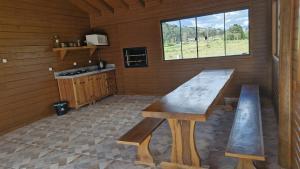 a kitchen with a wooden table and benches in a room at Pousada Caminhos da Serra in Bom Retiro