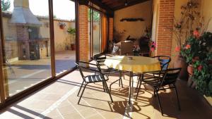 eine Terrasse mit Tisch und Stühlen auf einer Veranda in der Unterkunft Casa Rural Rosa in Villafruel