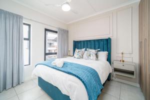 a bedroom with a large bed with a blue headboard at Ballito Hills 164 in Ballito +38 photos