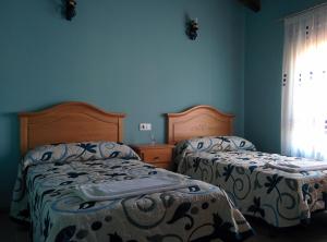 2 Betten in einem Schlafzimmer mit blauen Wänden in der Unterkunft Casa Rural Rosa in Villafruel + 16 Fotos