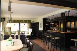 a restaurant with a bar and tables and chairs at Landgasthaus Veltheimer Hof in Porta Westfalica