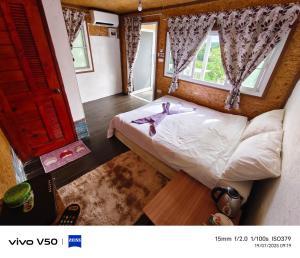 a small bedroom with a bed and a window at พูลวิลล่าminiบ้านสวนเกดกนกเขาค้อ in Phetchabun