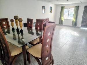 a dining room with a glass table with a chess board at Hostal La FLora in Cartagena de Indias