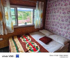 a small bed in a room with a window at พูลวิลล่าminiบ้านสวนเกดกนกเขาค้อ in Phetchabun