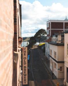 a woman standing on a balcony with a sign that reads theinylinyl at The Distillery Room in Scarborough