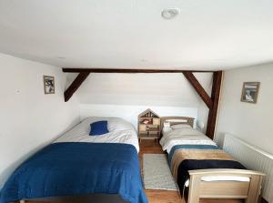 two twin beds in a room with wooden floors at Maison familiale alsacienne au centre ville in Obernai
