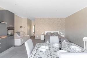 a kitchen and living room with a table and a bed at Aura Suite near Lake Garda in Castiglione delle Stiviere
