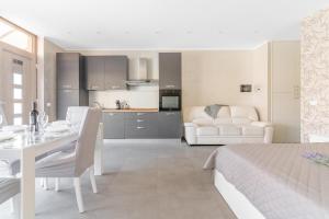 a white room with a dining table and a kitchen at Aura Suite near Lake Garda in Castiglione delle Stiviere +18 photos