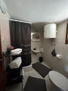 a bathroom with a black shower curtain and a toilet at Apartments Kety in Jezera +12 photos