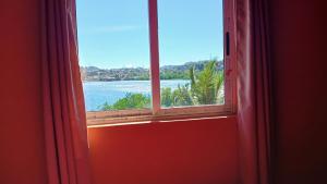a window with a view of a body of water at CHAMBRE LA TERRASSE Nosy-be in Hell-Ville