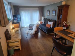 a living room with a couch and a table at KNUS tiny gardenhouse in Doorn