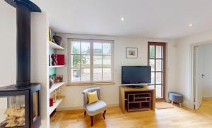 TV a/nebo společenská místnost v ubytování Au bord de l'Odon