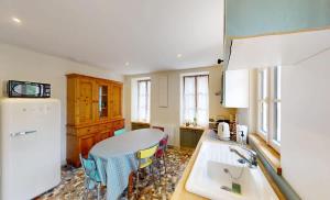a kitchen with a white refrigerator and a table at Au bord de l'Odon in Louvigny +20 photos