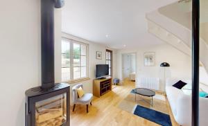 a living room with a fireplace and a couch at Au bord de l'Odon in Louvigny