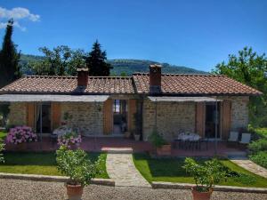ローロ・チュッフェンナにあるCozy Farmhouse with Swimming Pool in Tuscanyの庭園とパティオ付きの石造りの家