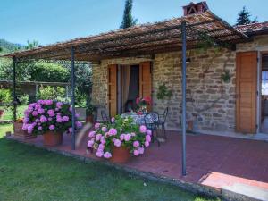 un patio con flores en macetas frente a una casa en _x000D_ Farmhouse in Loro Ciuffenna, en Loro Ciuffenna 32 fotos más