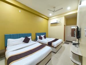 Giường trong phòng chung tại Varanasi Hotel Kashi Heaven Premium Near Baba Vishwanath Temple & Ganga Ghat - Spacious Spotless Rooms With Wi-fi Facility #Parking And Excellent Customer Service - Best Hotel In Varanasi - Book Now