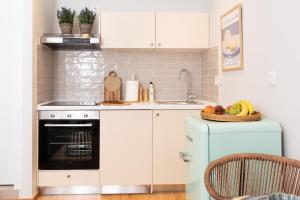 uma cozinha com armários brancos e um forno azul em Porta Rem Studio by Konnect, Old Corfu Town em Corfu Town