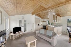 a living room with a couch and a tv at Lilac Lodge at Pound Farm in Crook