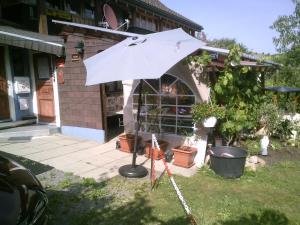 a white umbrella in front of a building at Wannenhof Romantik in Bernau im Schwarzwald