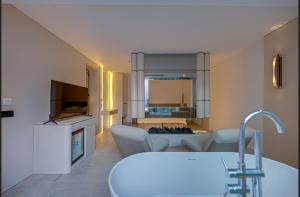 a living room with a couch and a living room with a tv at VENTO MARE LUXURY Hotel in Cesme