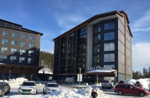 a large building with cars parked in a parking lot at Levi Chalets 1508 Visit Levi in Levi
