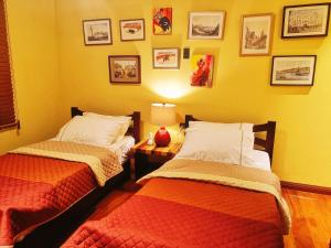 two beds in a bedroom with a lamp and pictures on the wall at Casa Acantilado Oslob - 3BR in Oslob