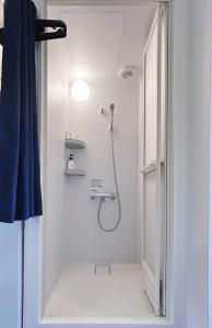 a shower in a white bathroom with a light at Ueno-Tokyo Garden in Tokyo