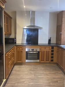 a kitchen with wooden cabinets and a stove top oven at 52 - room 1 - city views in Swansea +2 photos