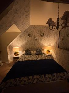 a bedroom with a bed with a black blanket and two lamps at Agnes Little Corner in Honfleur