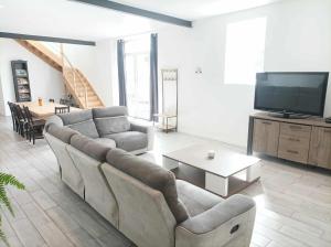 a living room with a couch and a tv at Ti Guernevez - La Longère in Briec
