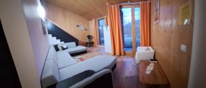 a living room with white couches and a window at Centrul 3H in Sub Piatra