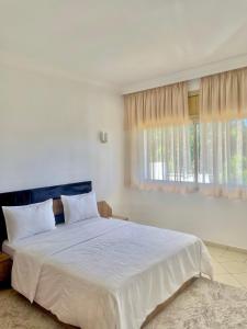 a white bedroom with a large bed and a window at villa dar esalam in Rabat +41 photos