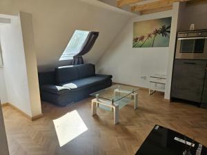 a living room with a blue couch and a table at Rooftop Retreat Heilbronn in Heilbronn
