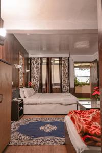 a bedroom with two beds and a large window at Azalea Holidays On Mall in Darjeeling
