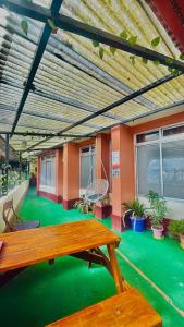 a room with a wooden table and green floor at Azalea Holidays On Mall in Darjeeling