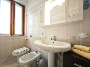 Un baño blanco con lavabo e inodoro. en Terrazza Su Crosio a Clusone in centro!, en Clusone