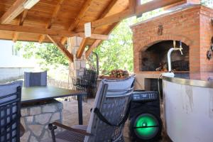 a patio with a table and a brick oven at Buško Escape beach in Tomislavgrad