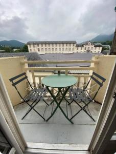 une table et deux chaises sur un balcon dans l'établissement Cocon Thermal, appartement cosy 2 à 4 pers, proche Centre et Thermes, à Bagnères-de-Bigorre