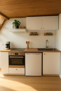 a kitchen with white cabinets and a sink at Home Sweet Zen, appartement près de la gare St Jean in Bordeaux