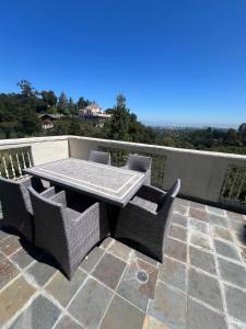 a patio with a table and chairs on a balcony at Big Bright Burlingame Hills Bay View Home in Burlingame