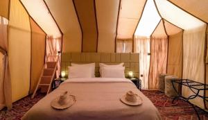 Ένα ή περισσότερα κρεβάτια σε δωμάτιο στο Luxury Merzouga Desert Camp