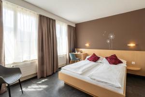a hotel room with a bed and a desk at Hotel Blume Interlaken in Interlaken +12 photos