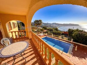 a balcony of a house with a swimming pool at Villa Marietta, private pool villa with sea views and terrace, perfect for families and remote stays in Almuñécar