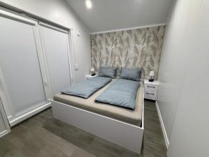 a small bedroom with a bed with blue pillows at TRB - Tiny Rooms Bodensee 1 in Gaißau