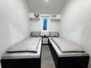 a room with two beds in it with a window at TRB - Tiny Rooms Bodensee 1 in Gaißau