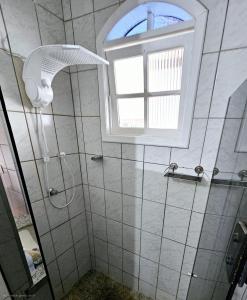 a bathroom with a shower and a window at Hostel Castelo in Belo Horizonte