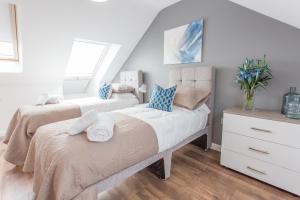 een slaapkamer met twee bedden en een raam bij Modern 1 & 2 Bedroom Apartments in Oxford, Near Hospitals & Science Park in Oxford +54 foto's